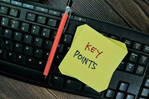 Concept of Key Points write on sticky notes isolated on Wooden Table. photo