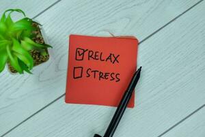 No Stress and Relax write on sticky notes isolated on Wooden Table. photo