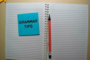Grammar Tips write on a sticky note isolated on office desk. photo