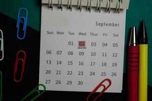 Top view September monthly Calendar and marked 2nd labor day isolated on office desk photo