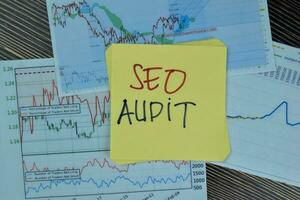 Concept of SEO Audit write on sticky notes isolated on Wooden Table. photo