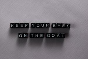 Keep your eyes on the goal on wooden blocks. Motivation and inspiration concept photo