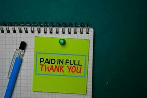 Paid in Full - Thank You write on a sticky note isolated on green background. photo