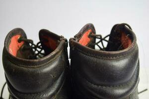 Close up of a brown old boots isolated on white background photo