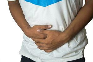 Man suffering from sick stomach and unhappy isolated on white background. Selective focus in shirt. photo