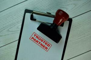 Red Handle Rubber Stamper and Trusted Partner text isolated on the table. photo