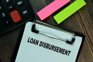 Loan Disbursement write on a paperwork isolated on Wooden Table. Finance concepts photo