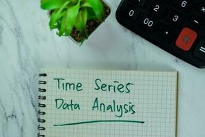 Concept of Time Series Data Analysis write on a book with statistics isolated on Wooden Table. photo