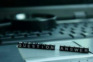 Question Answer text wooden blocks in laptop background. Business and technology concept photo