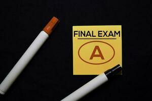 Final Exam and A in red circle on sticky notes isolated on black background photo
