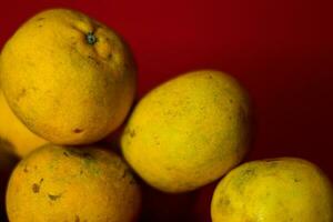 Fresh orange fruit in the red background photo