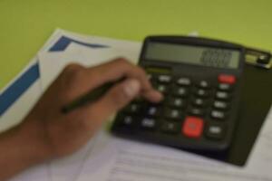 Blur and defocused calculate about cost and doing finance at home office. Business and Finance Concept photo