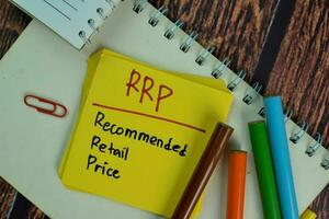 RRP - Recommended Retail Price write on sticky notes isolated on Wooden Table. photo