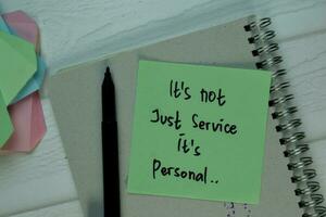 It's not Just Service It's Personal write on sticky note isolated on Wooden Table. photo