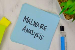 Malware Analysis write on sticky notes isolated on Wooden Table. photo