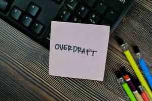 Concept of Overdraft write on sticky notes isolated on Wooden Table. photo