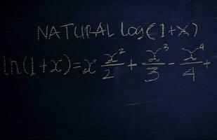 Close up math formulas written on a blackboard. Education concept photo