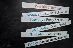 Close up making agenda weekly schedule on personal organizer. Business and entrepreneur concept. Isolated on blackboard photo