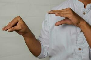 Close up Asian man shows hand gestures it means NO isolated on white background. American sign language photo