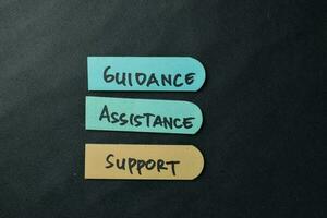 Guidance, Assistance, Support write on sticky notes isolated on office desk. photo
