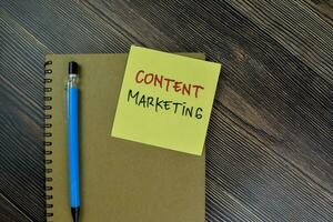 Concept of Content Marketing write on sticky notes isolated on Wooden Table. photo