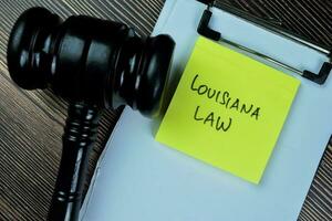 Concept of Louisiana Law write on sticky notes with gavel isolated on Wooden Table. photo