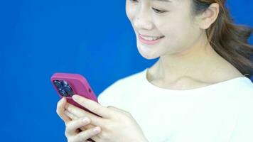 asiatisk kvinna bär hörlurar spelar mobil telefon i cyber samhälle video