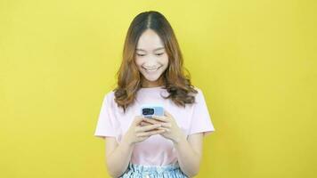 Aziatisch vrouw chatten Aan mobiel telefoon schattig roze overhemd video