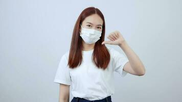 Aziatisch Dames zijn geadviseerd naar slijtage een wit overhemd en jeans vervelend een masker net zo een teken van gevoel slechte. video