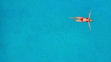 View from the top as a woman in a red swimsuit swims in the pool video