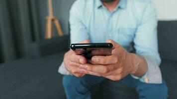 homme séance sur une confortable canapé et travail sur portable et téléphone intelligent. concept de éloigné travail video