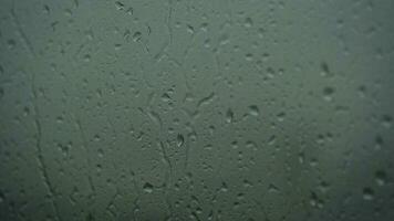 fechar acima do uma vidro com água gotas enquanto lado de fora é chovendo. gotas do chuva através vidro. video