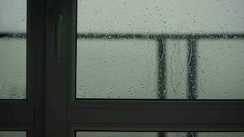 lourd pluie verse vers le bas le meubles sur le balcon ou terrasse. gouttes courir vers le bas le verre de le clôture video