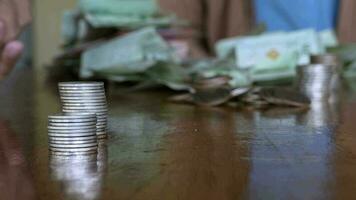 manos de un pobre rural joven chico contando monedas en un de madera mesa, en un económico recesión me gusta hoy, ahorro dinero es un importante importar ese debería no ser pasado por alto., ahorros concepto video