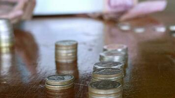 Hands of a poor rural young boy counting coins on a wooden table, In an economic downturn like today, saving money is an important matter that should not be overlooked., savings concept video