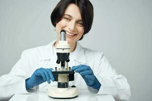 female scientist in white coat laboratory microscope science experiment photo