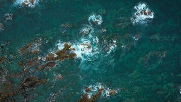 Top view of the surface of the Atlantic Ocean with rocks protruding from the water off the coast of the island of Tenerife, Canary Islands, Spain. video