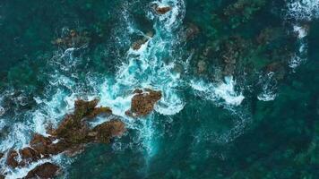 oben Aussicht von das Oberfläche von das atlantisch Ozean mit Felsen hervorstehend von das Wasser aus das Küste von das Insel von Teneriffa, Kanarienvogel Inseln, Spanien. video