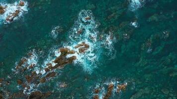 Top view of the surface of the Atlantic Ocean with rocks protruding from the water off the coast of the island of Tenerife, Canary Islands, Spain. video