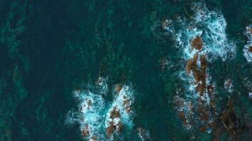 oben Aussicht von das Oberfläche von das atlantisch Ozean mit Felsen hervorstehend von das Wasser aus das Küste von das Insel von Teneriffa, Kanarienvogel Inseln, Spanien. video