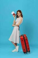 Woman in white dress red suitcase travel destination blue background photo