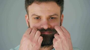 Porträt von ein bärtig Mann Wendungen seine Schnurrbart video