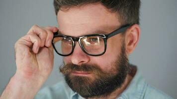 portrait de une Beau barbu met sur le sien des lunettes et rebondissements le sien moustache video