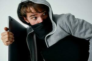 hacker crime anonymity caution balaclava light background photo