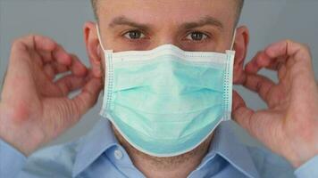pandemisch bescherming van de covid-19 coronavirus. gebaard Kaukasisch Mens zet Aan een beschermend medisch masker. virus bescherming. video