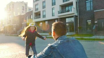 fille court à papa et câlins lui. père choix en haut le enfant dans le sien bras et cercles sa video