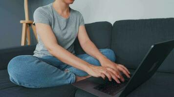 femme séance sur une confortable canapé et travail sur une portable et téléphone intelligent. concept de éloigné travail. Accueil Bureau video