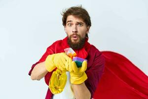 hombre con detergente limpieza profesional rojo impermeable recortado ver de tareas del hogar foto