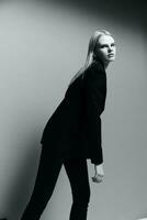 un joven elegante niña en un chaqueta poses en un negro y blanco estudio. un concepto para ropa marcas frio oferta bandera para rebaja foto