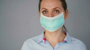 pandemia proteção do a covid-19 coronavírus. caucasiano mulher dentro uma médico face mascarar. vírus proteção. video